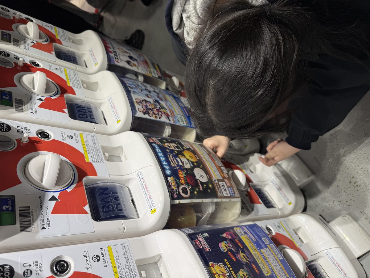 Daughter trying gachapon capsule machines in Ikebukuro