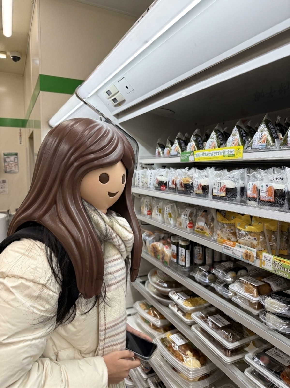 일본 편의점 삼각김밥과 도시락 진열대 앞에서 고르는 모습